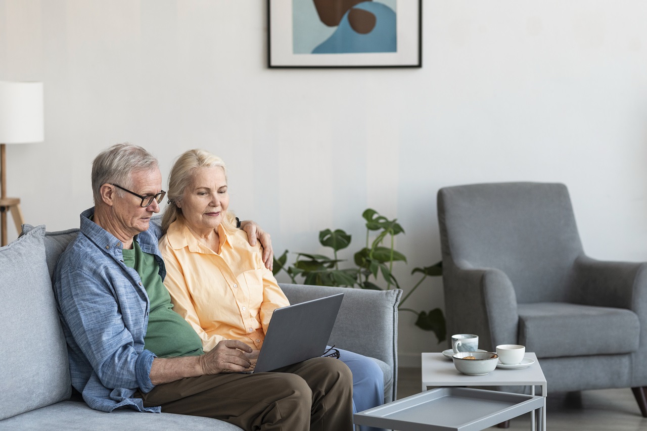 Coppia di pensionati con il computer portatile