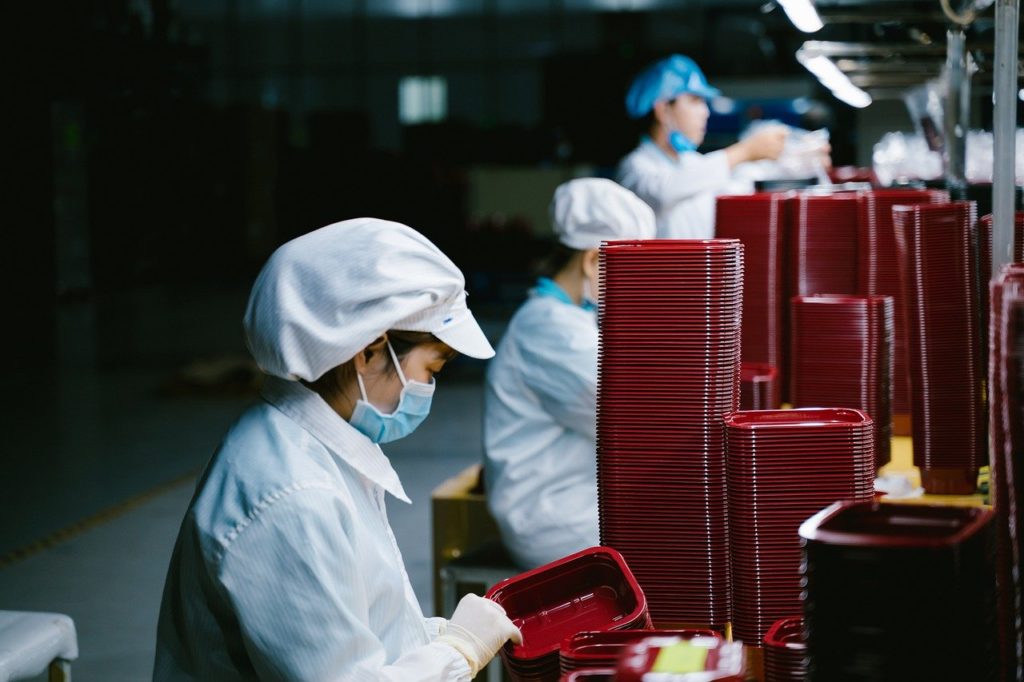 Donna al lavoro in fabbrica con la mascherina