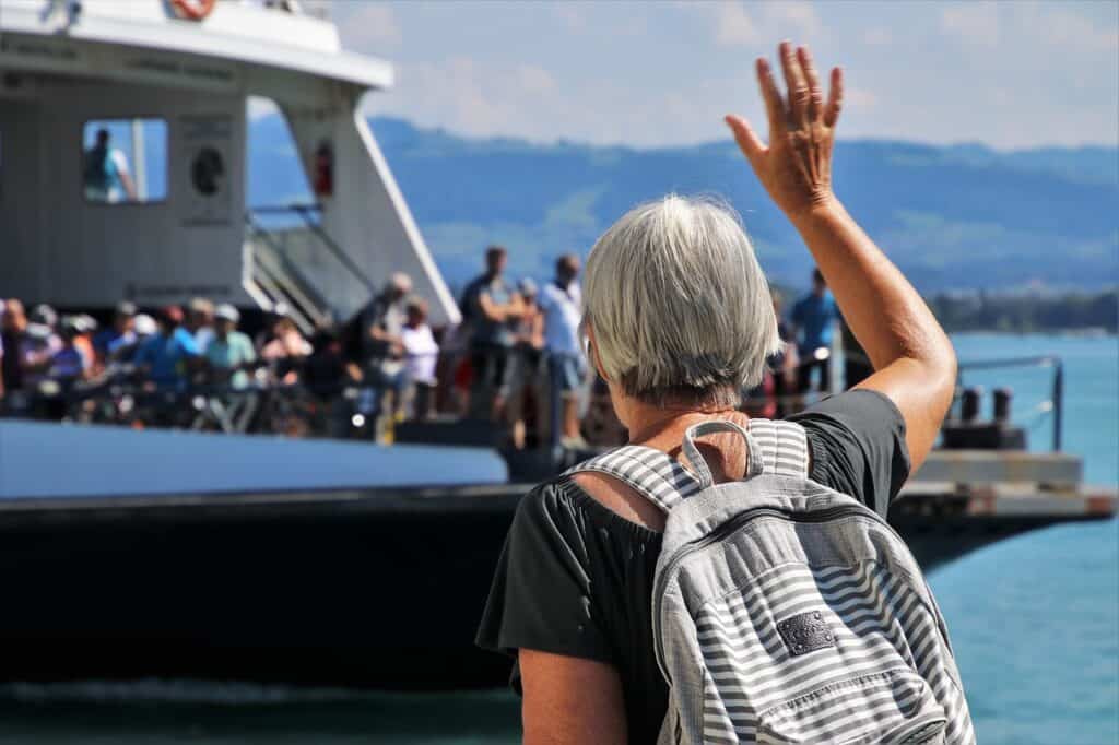 Donna anziana che saluta traghetto