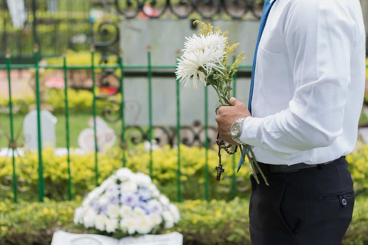 Uomo porta fiori al cimitero