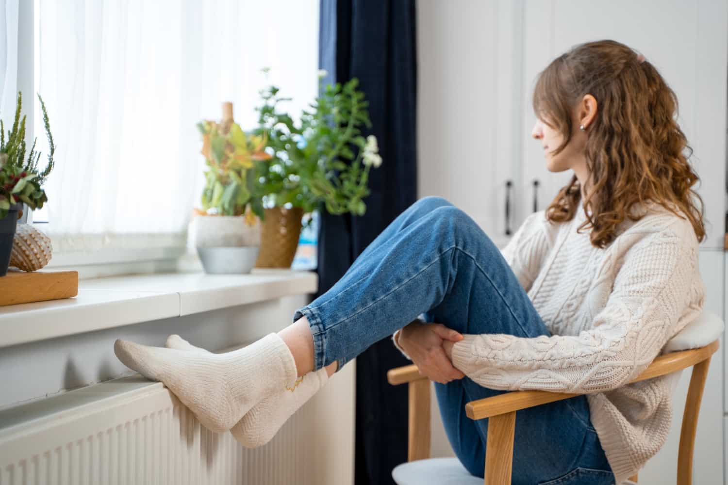 Ragazza che si scalda vicino al termosifone