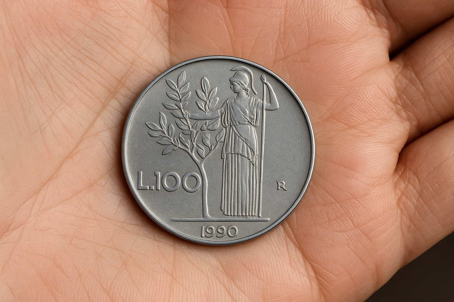 Primo piano realistico di una moneta da 100 lire italiana del 1990 con Minerva, posata sul palmo di una mano
